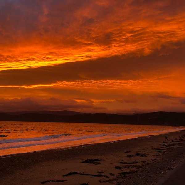 Red sky reflected in a pink-tinged ocean