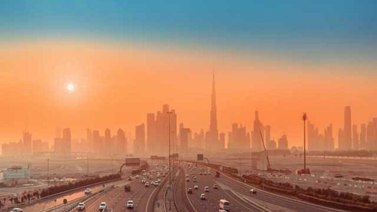 Roads in the forefront and a cityscape behind at sunrise