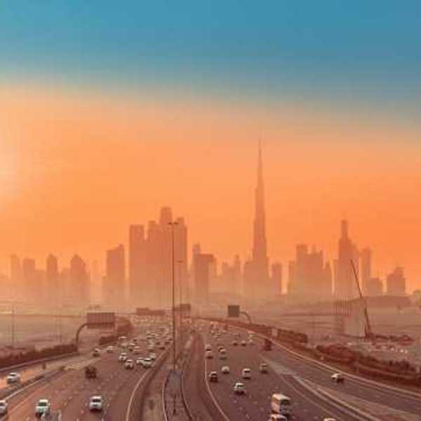 Roads in the forefront and a cityscape behind at sunrise