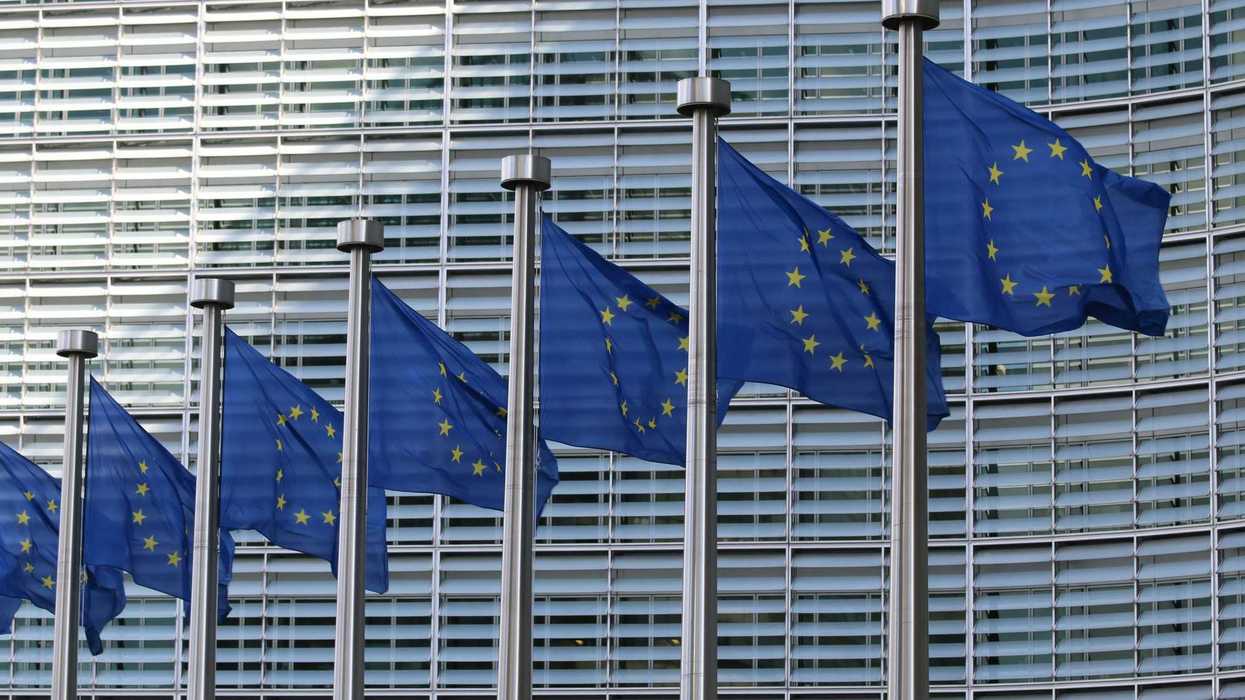 row of blue european union flags with yellow stars.