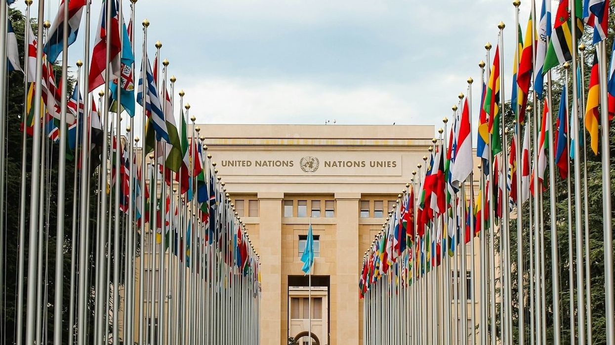 Rows of United Nations world flags outside UN building in Geneva, Switzerland.