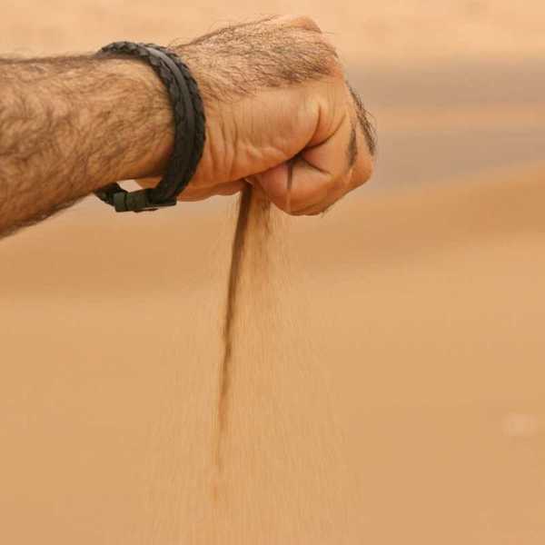 Sand sifting slowly through clenched hand.