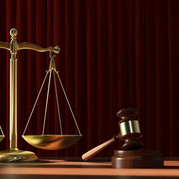 Scales of justice adjacent to a judges gavel signifying court ruling