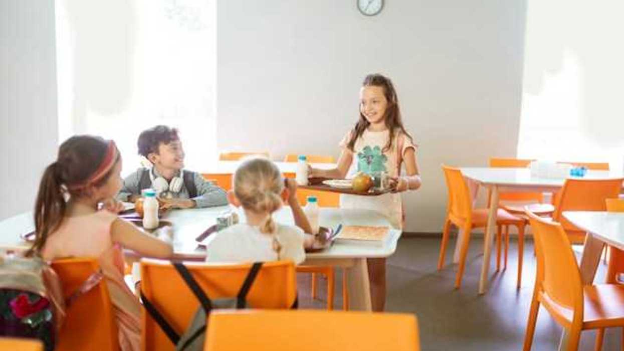School children sitting at a table eating their lunch