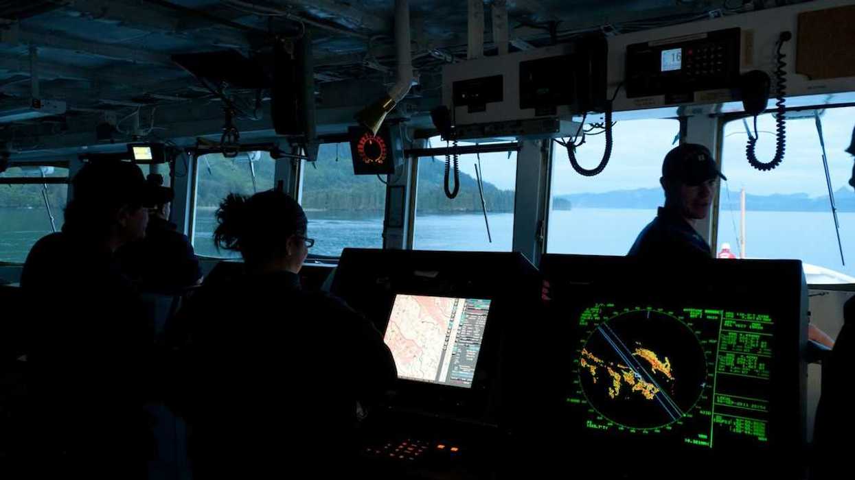 Scientific research vessel with 3 crew members surrounded by electronic instruments
