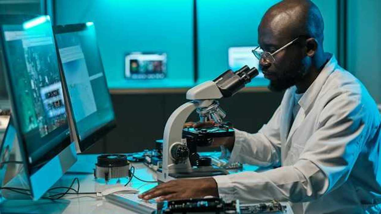 Scientist reviewing a slide on a microscope in a lab