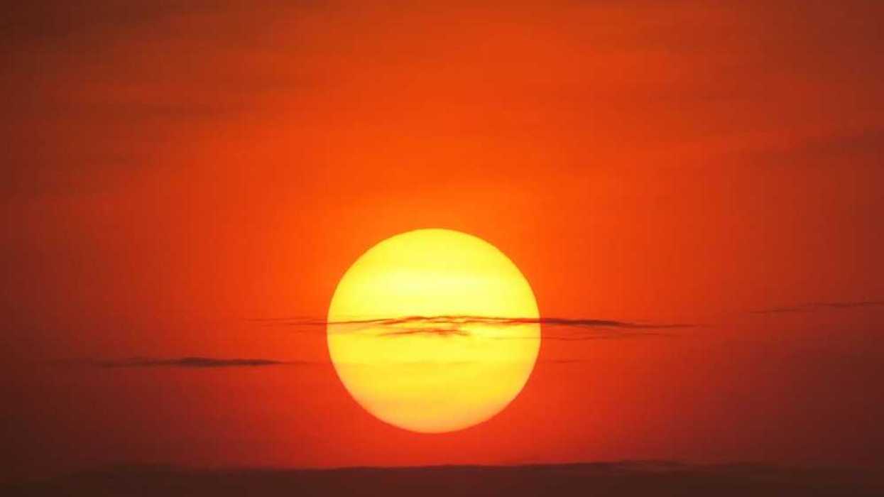 Setting sun at dusk against a red-orange sky