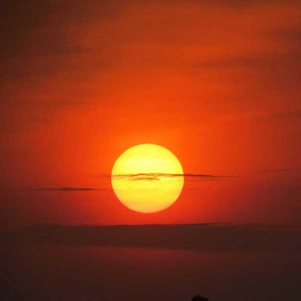 Setting sun at dusk against a red-orange sky