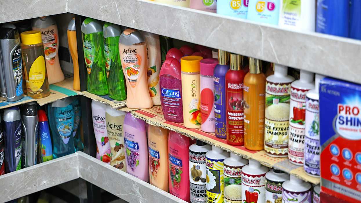 Shelves stocked with various bottles of shampoo and conditioner.