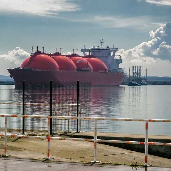 Ship and tugs are maneuvering at an LNG terminal