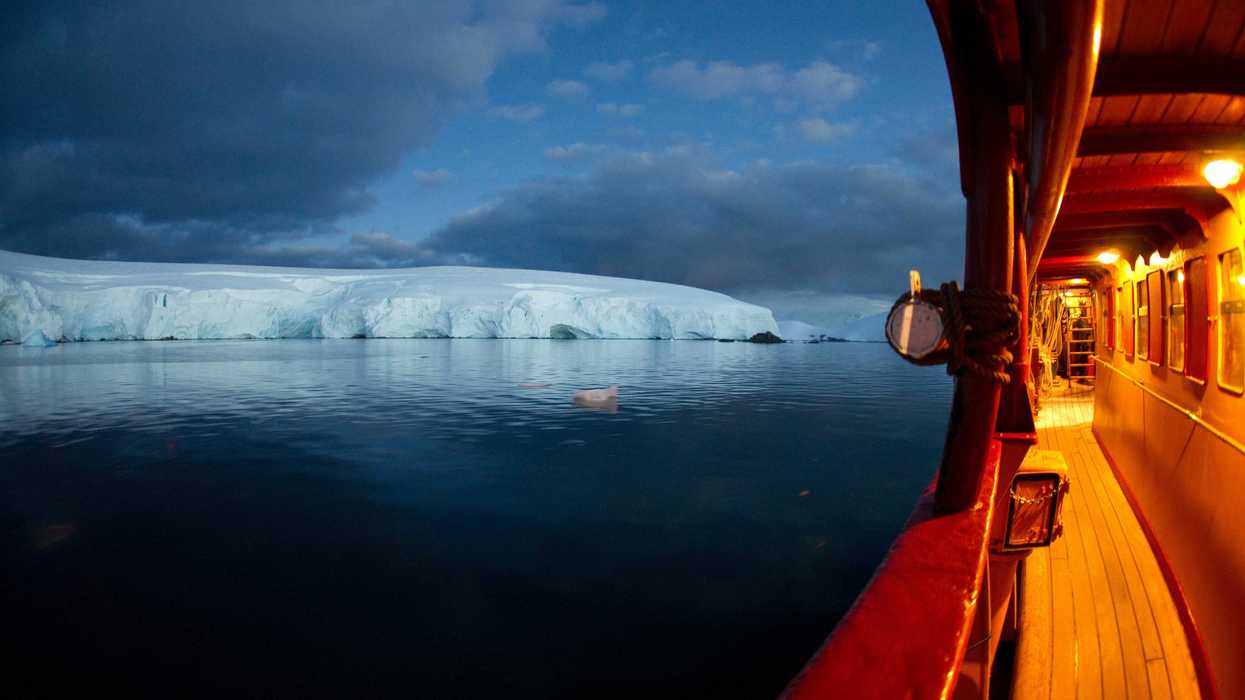 ship floating on ocean heading to ice burg