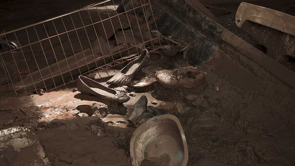 Shoes and kitchen utensils on the floor of a house that has been inundated by a mudslide