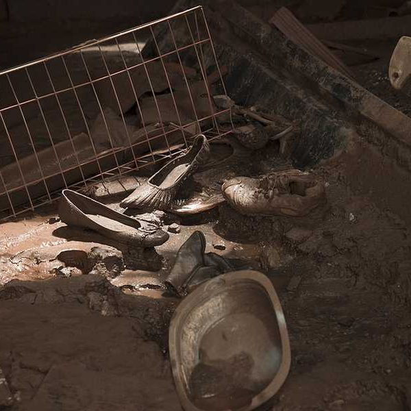 Shoes and kitchen utensils on the floor of a house that has been inundated by a mudslide