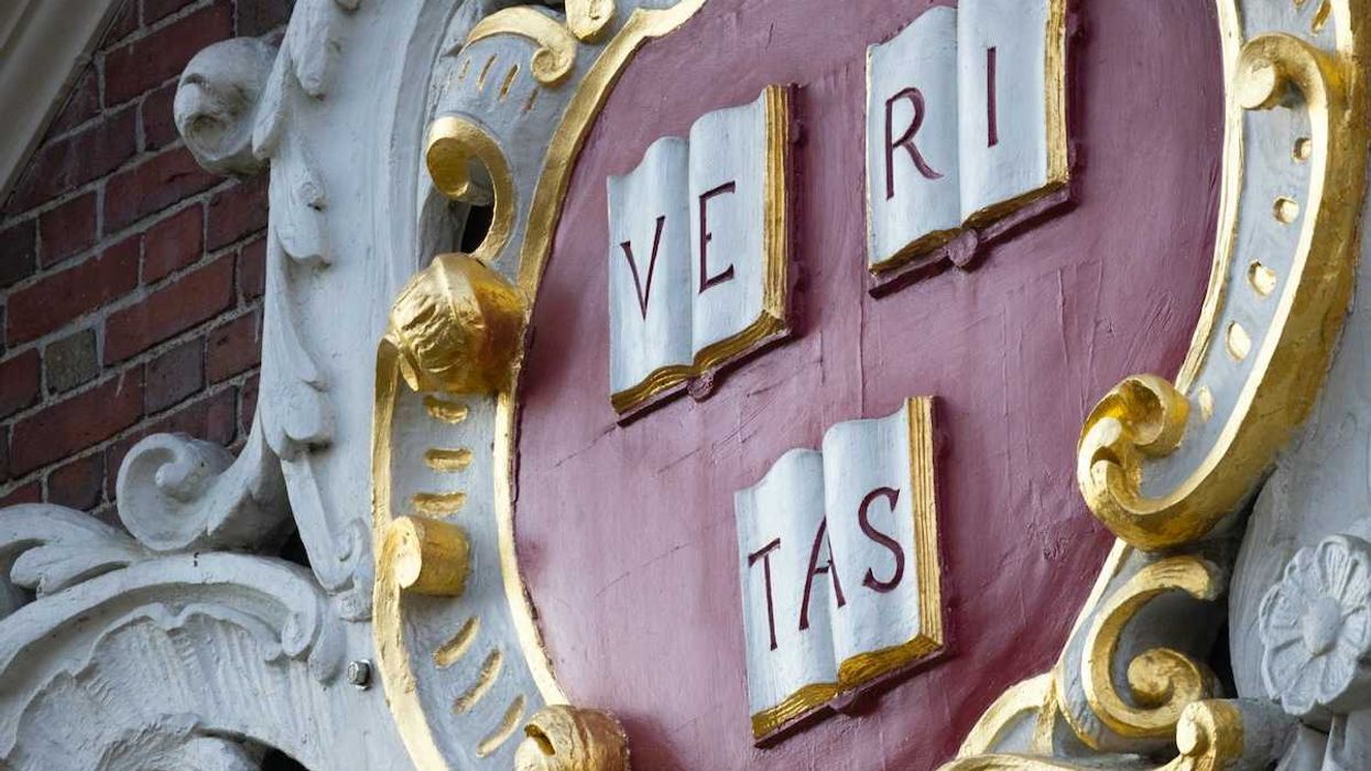 Sign on brick building at Harvard reads VE RI TAS