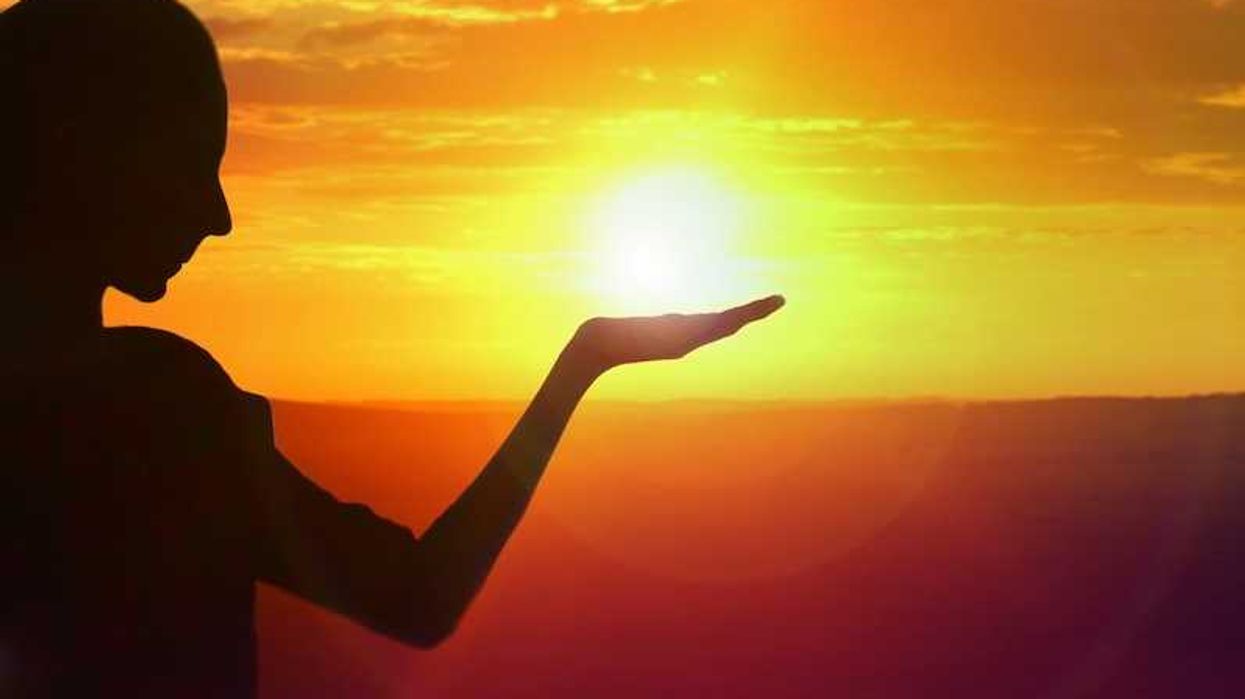 silhouette of a girl facing sunset, golden sky and water