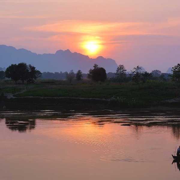 Silhouette of asian fisherman floating in the boat at the sunset in Hpa-An Myanmar