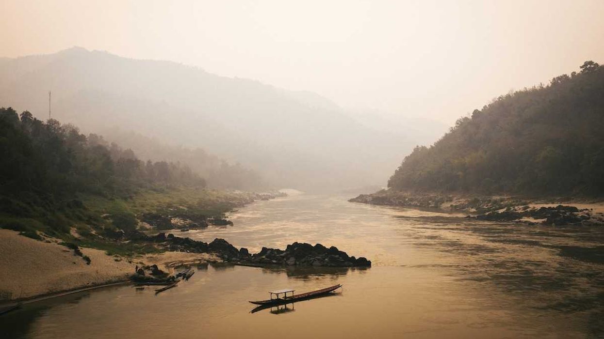 Single boat on misty Mekong River in Laos
