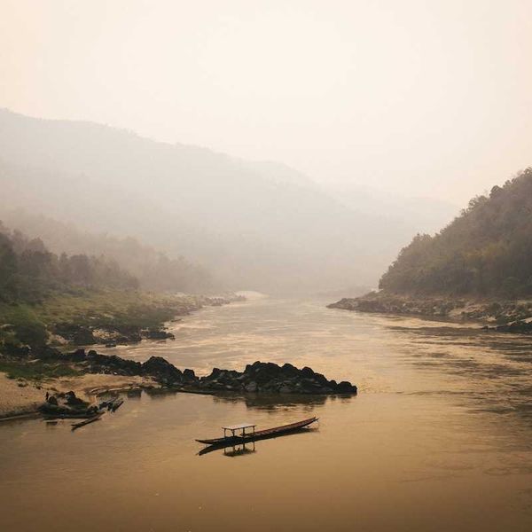 Single boat on misty Mekong River in Laos