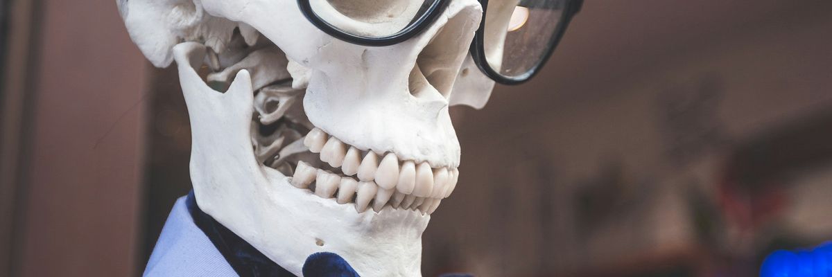 skeleton wearing eyeglasses and blue collared top