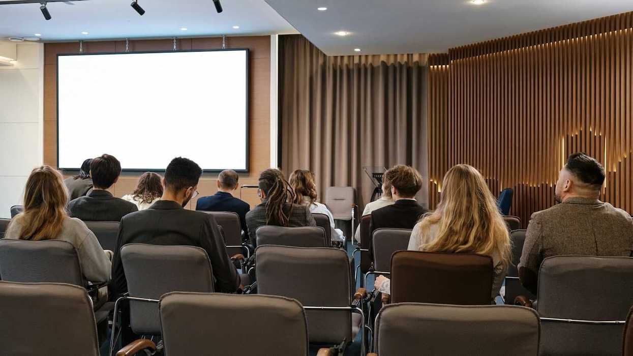 Small group of people seated in a conference room viewed from behind