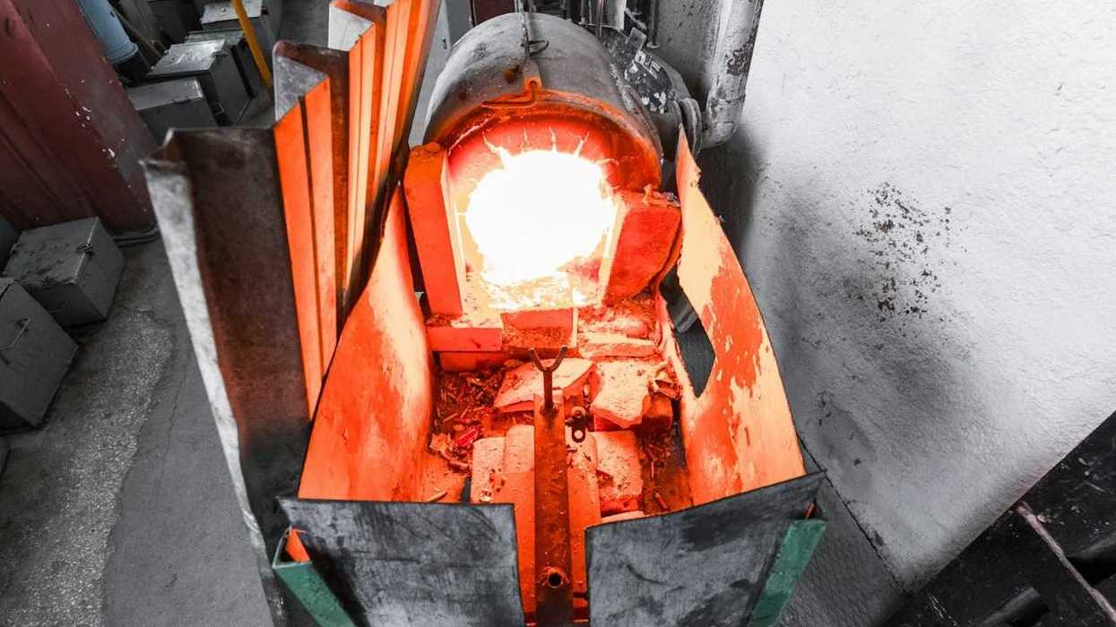 Small homemade trash burner, glowing cherry red from heat