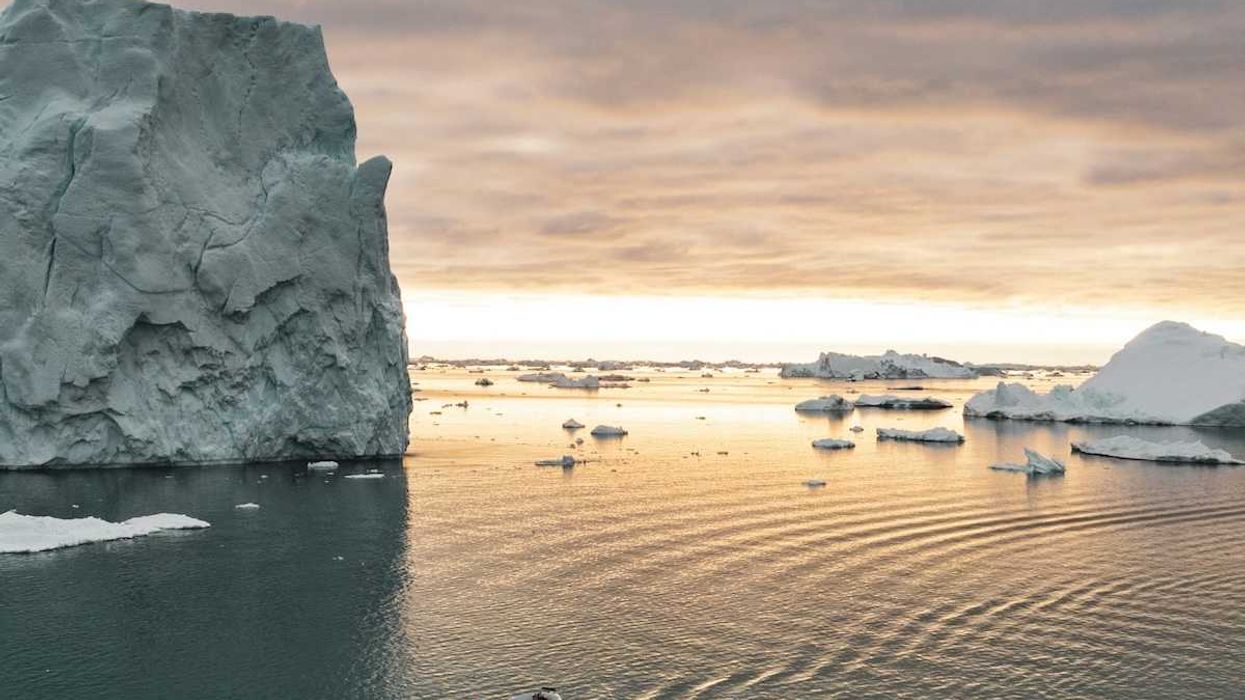 Small motorized boat navigating ice-choked waters off the coast of Greenland