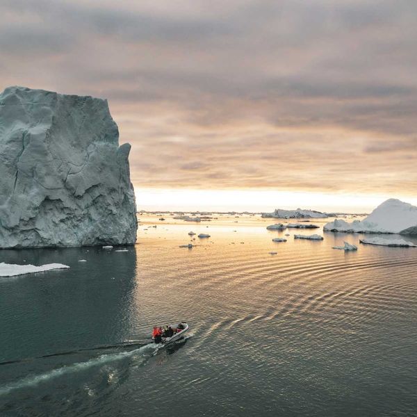 Small motorized boat navigating ice-choked waters off the coast of Greenland