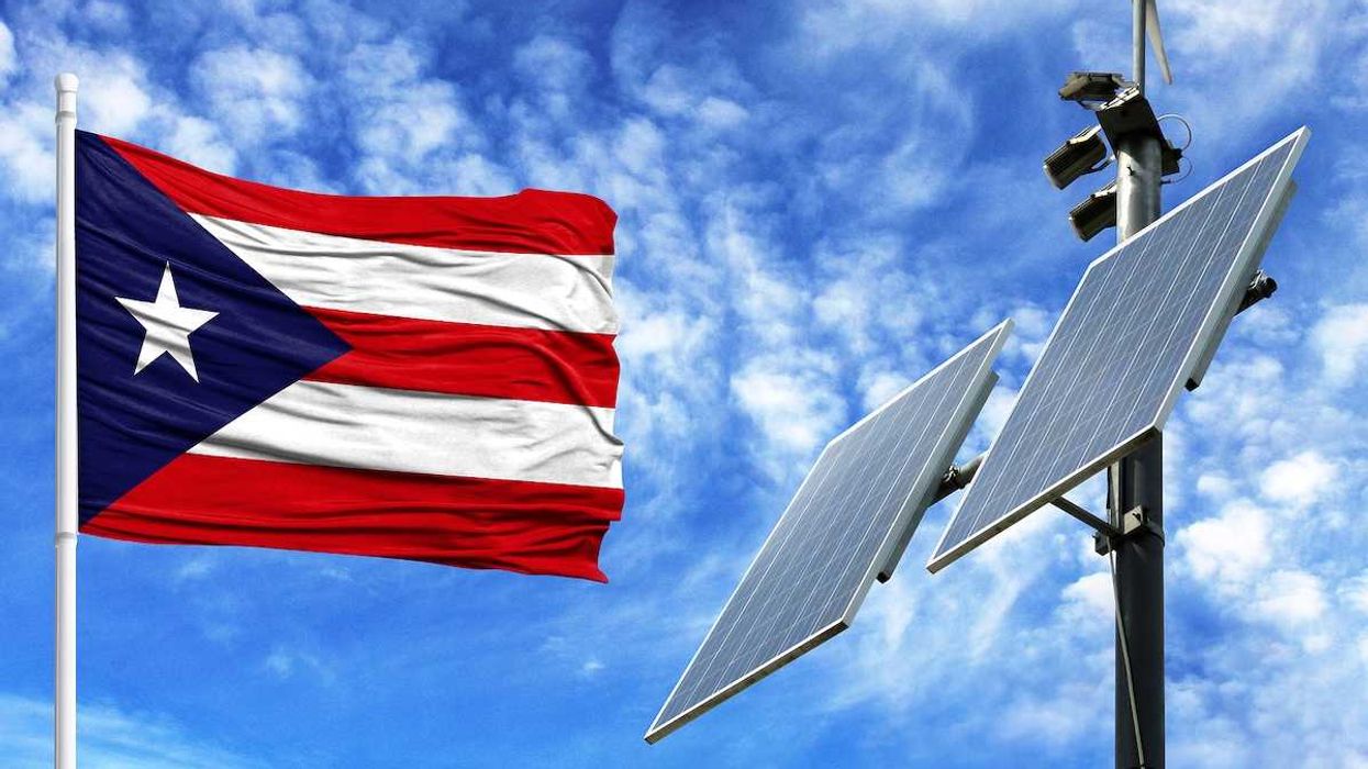 Solar panels on a background of blue sky with a flagpole and the flag of Puerto Rico
