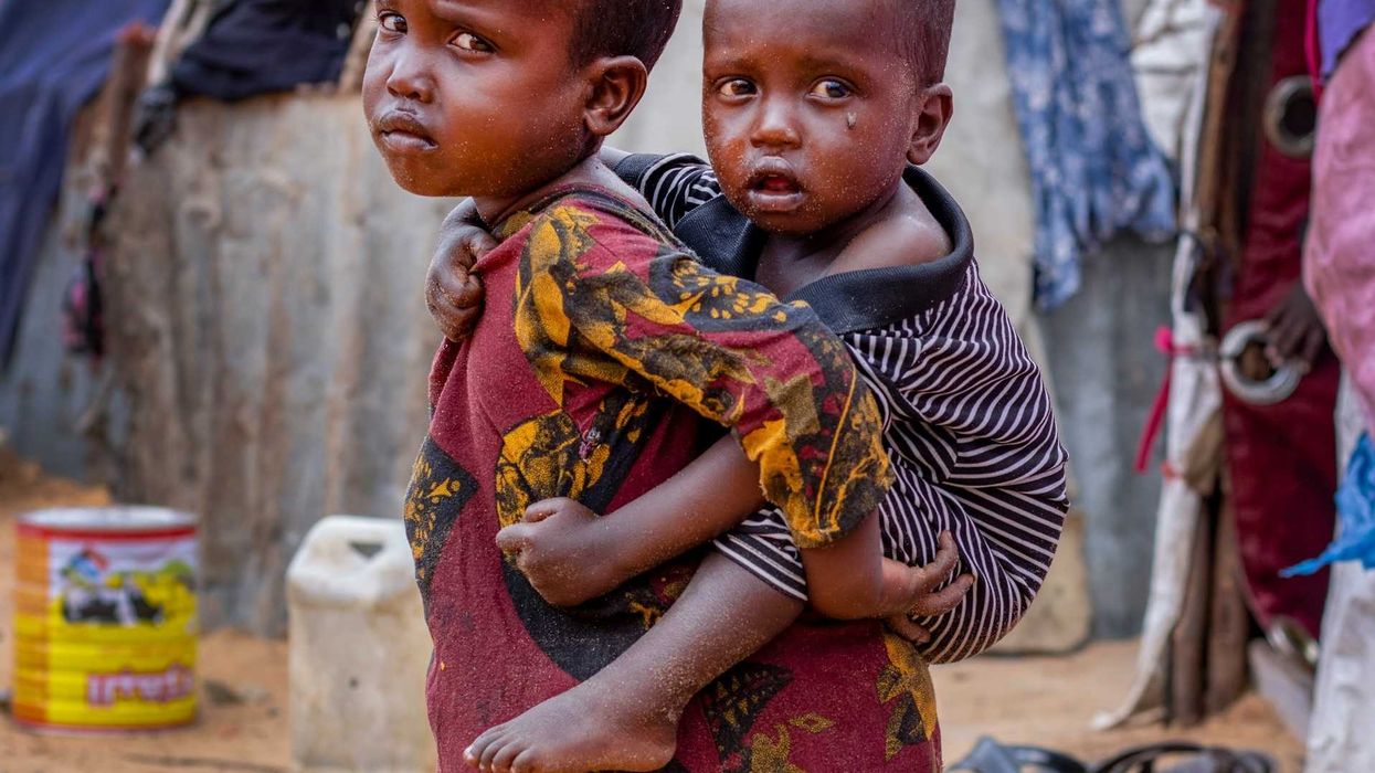 Somalian child carrying child on back