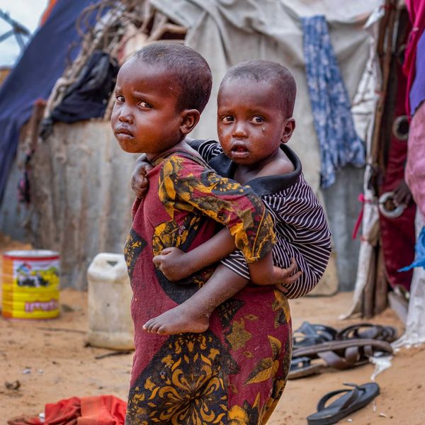 Somalian child carrying child on back