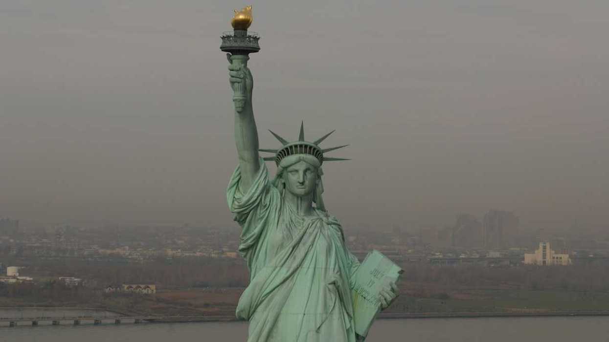 Statue of Liberty against a smoky, smoggy, sky and backdrop