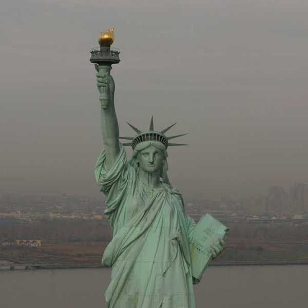 Statue of Liberty against a smoky, smoggy, sky and backdrop