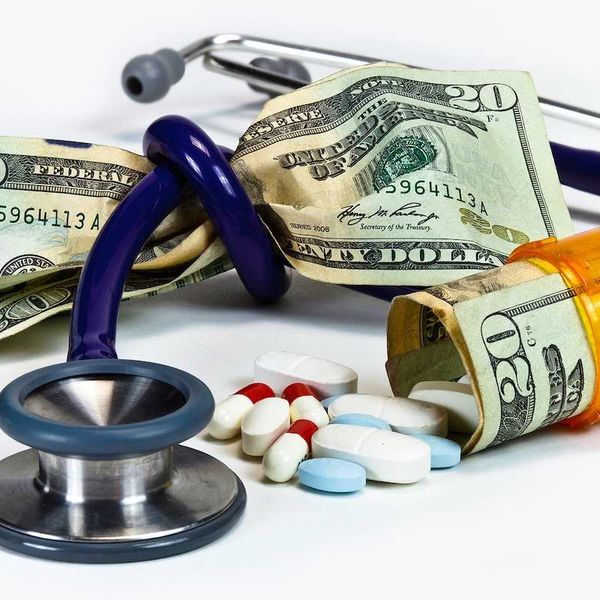 Stethoscope tied in a knot around a fist full of money