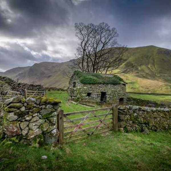 Stone house and fence on a cloudy day in a countryside setting