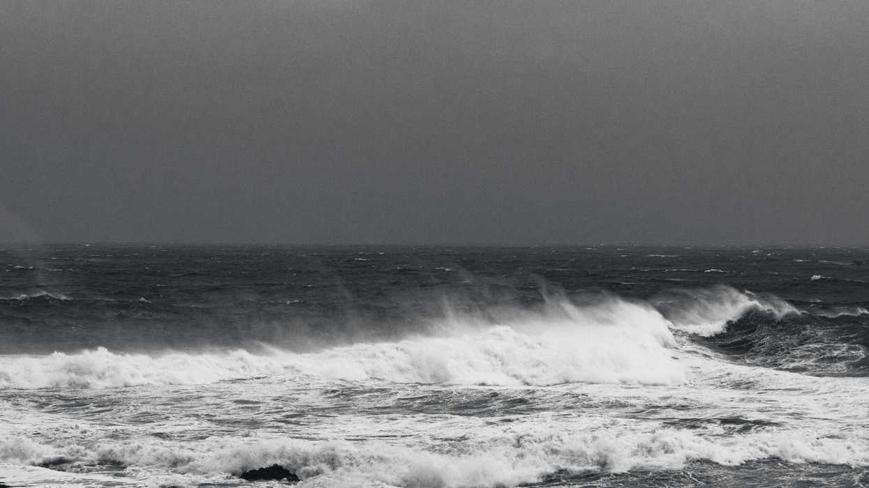 Stormy, white-capped ocean waves against dark stormy skies.