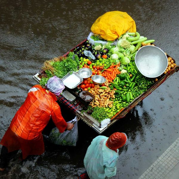 Street vendors push food cart through floodwaters