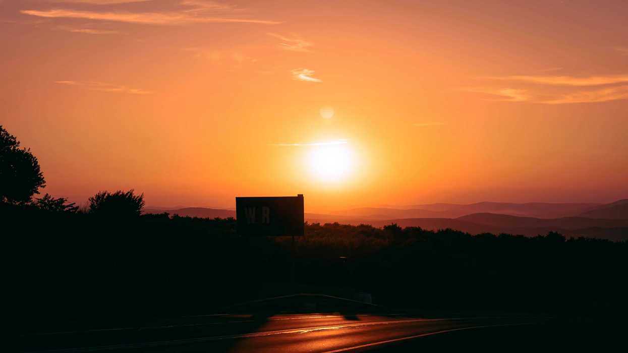 sunset over silhouetted hills.