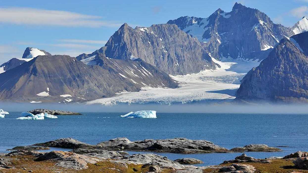 Svalbard region of Arctic archipelegio. Glacier flowing to sea from snowcapped peaks