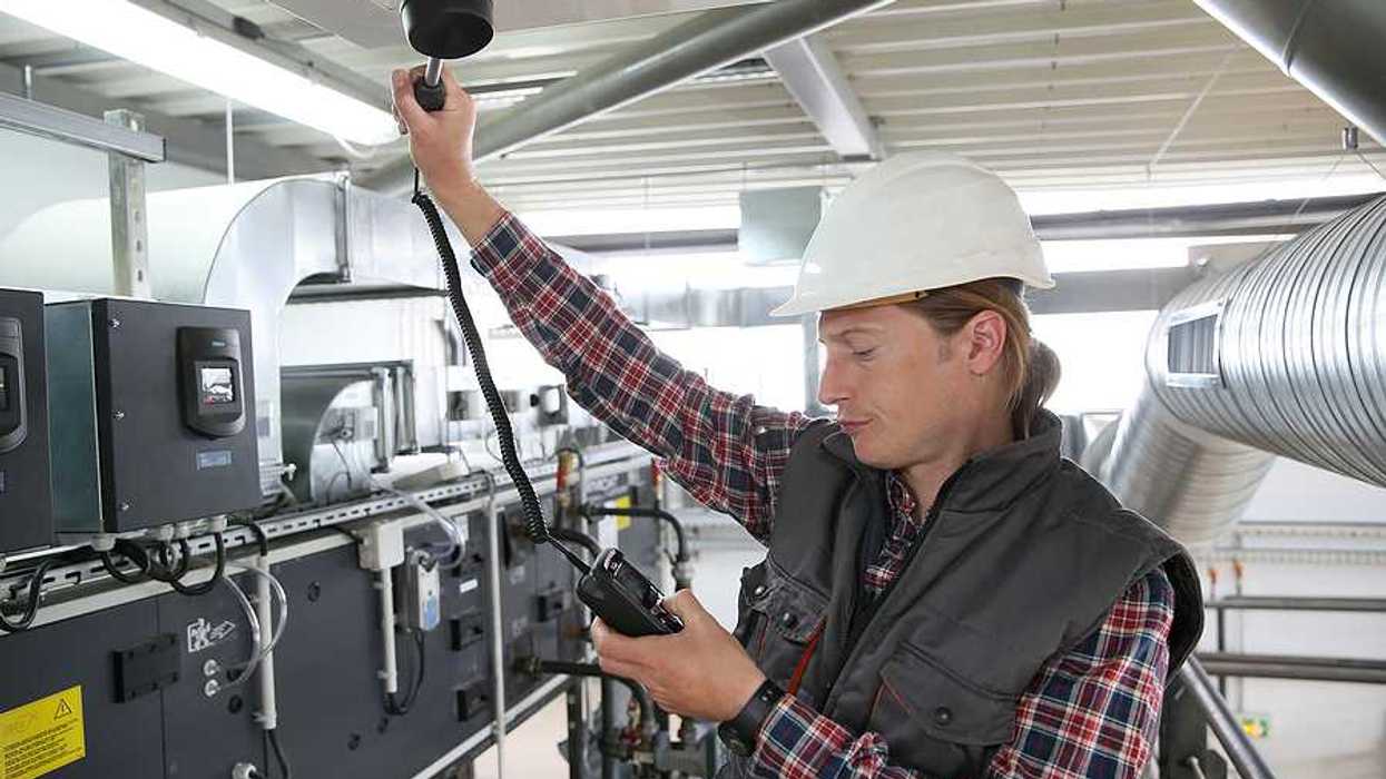 Technician testing and controlling air quality of heating equipment