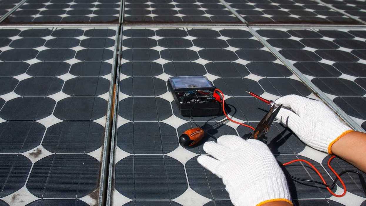 Technician using multimeter to repair photovoltaic modules