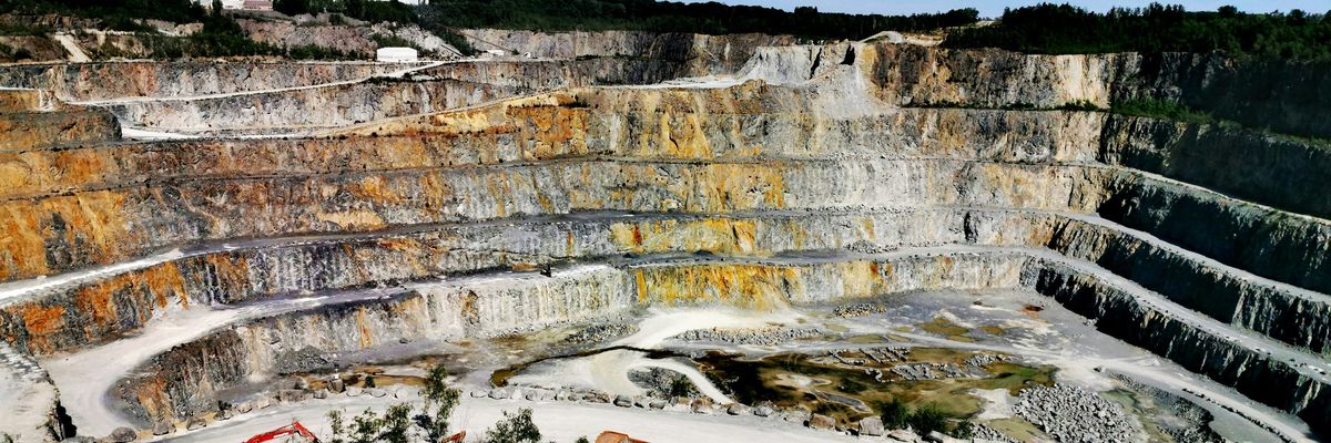 Terraced mining pit with green trees at the top.