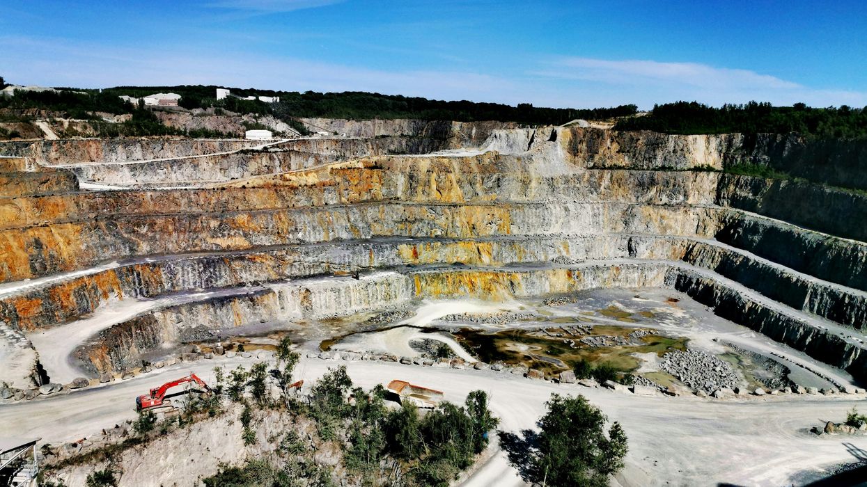 Terraced mining pit with green trees at the top.