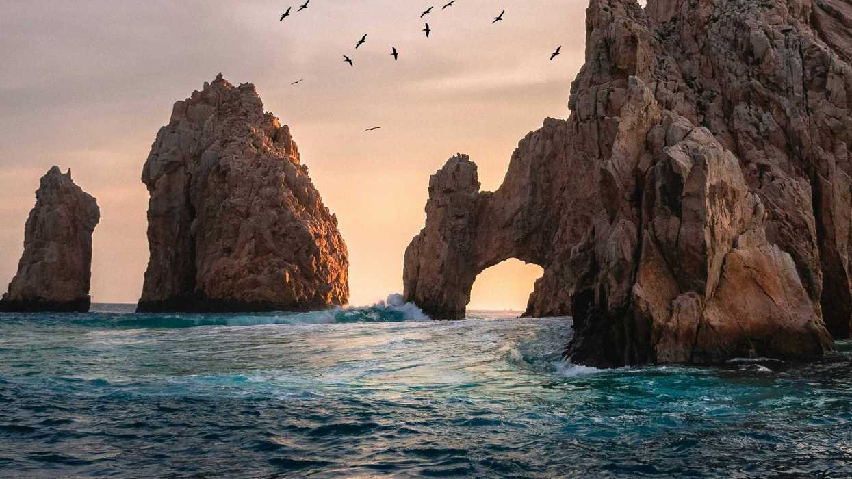 The Arch of Cabo San Lucas rising from the sea at low sun.