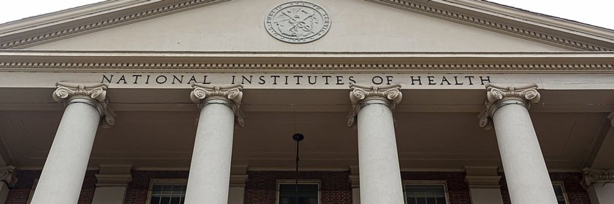 The entrance of the National Institutes of Health building with columns and red brick.