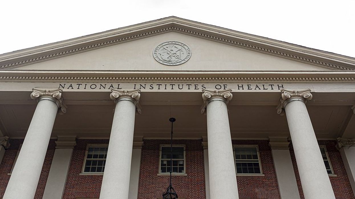 The entrance of the National Institutes of Health building with columns and red brick.