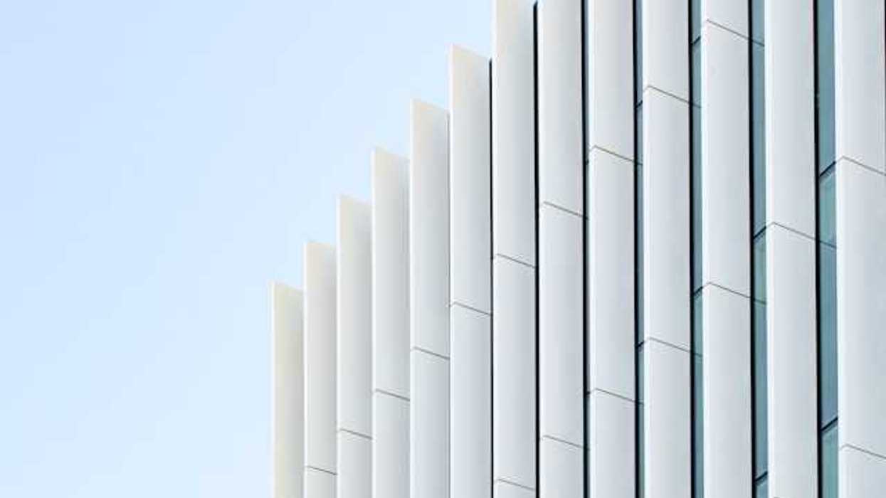 The side of a modern building with white columns and windows