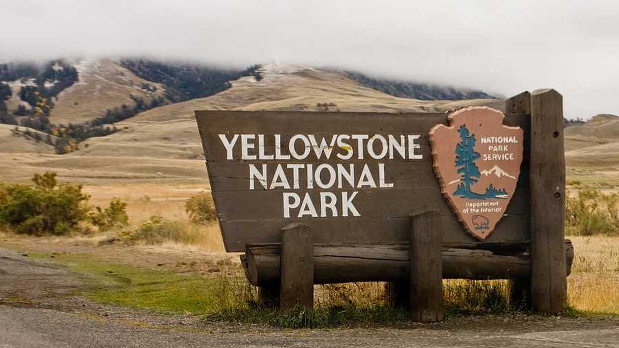 The sign upon entering Yellowstone National Park with hills int he background