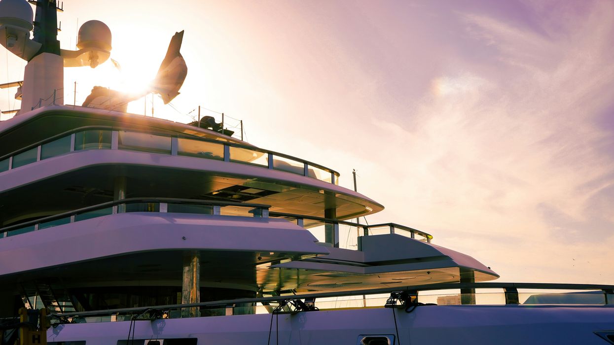 the sun is setting behind a large yacht.