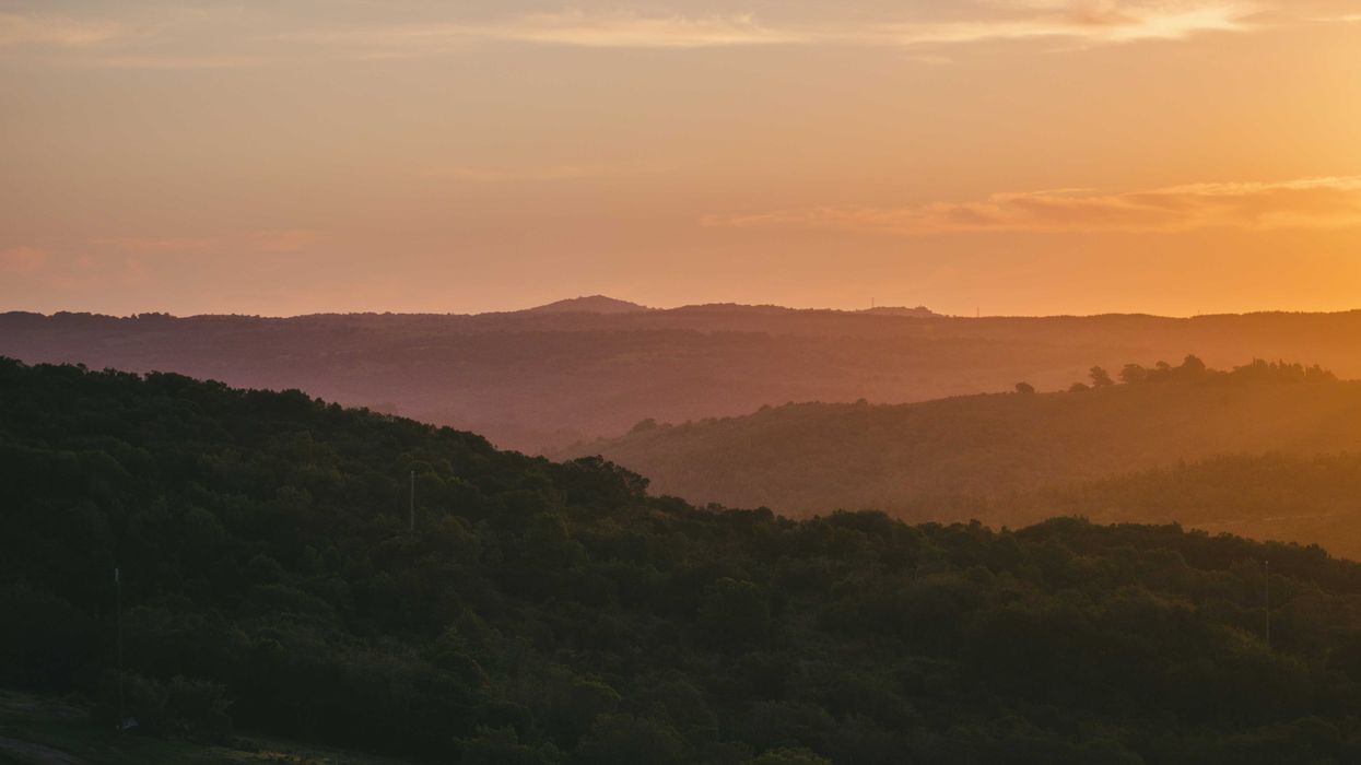 the sun is setting over a mountain range.