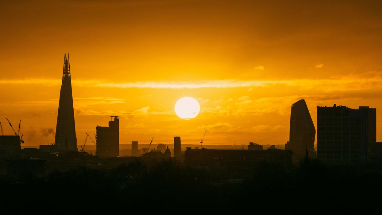 the sun is setting over the city of london.